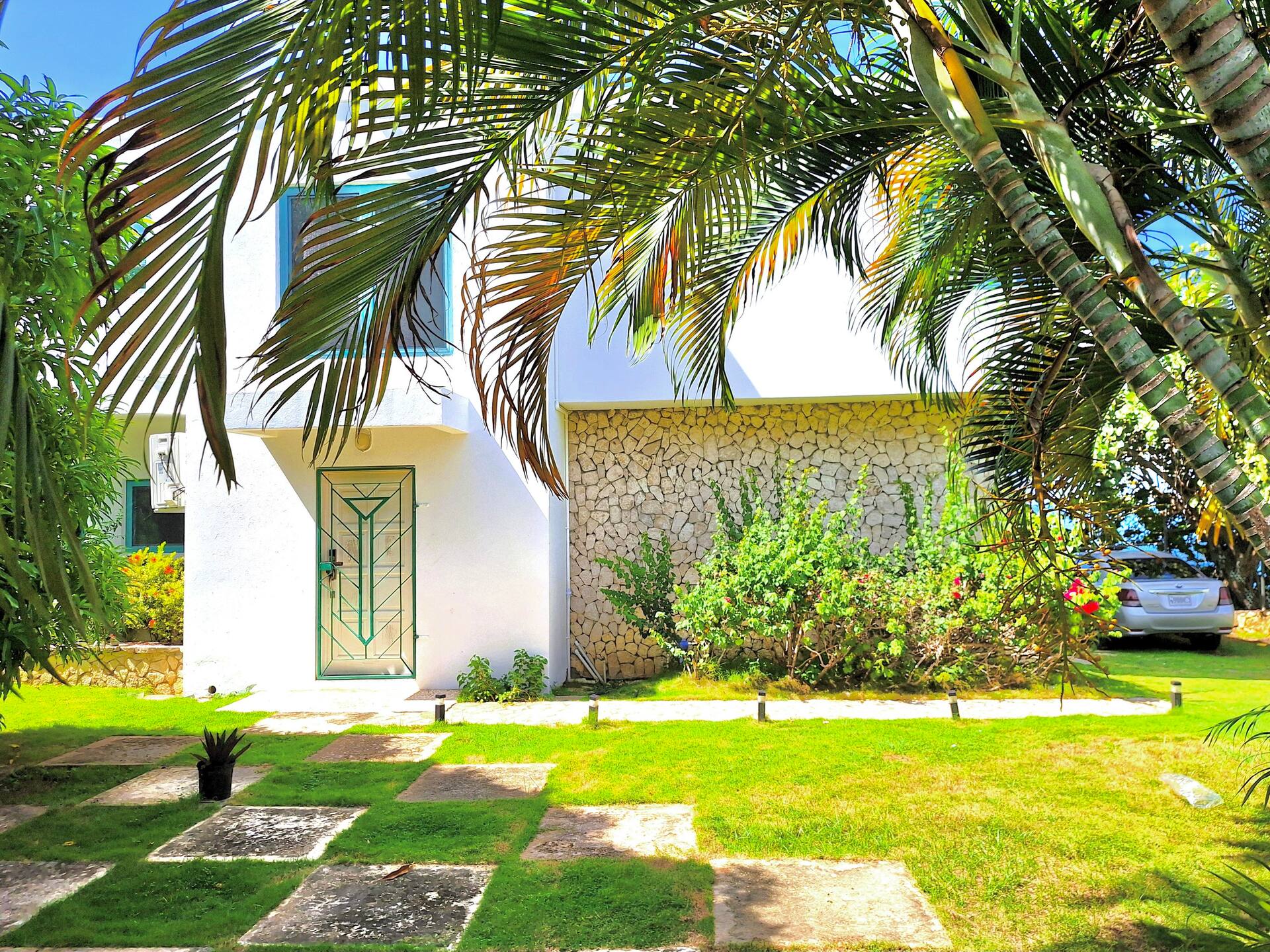 The Whispering Clouds Beach House in Jamaica, surrounded by palm trees